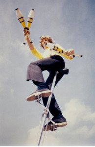 Kit Summers juggling on a tall unicycle
